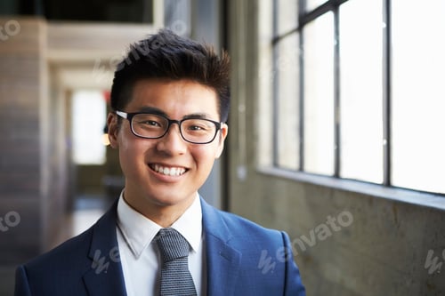 Preview: Young Asian businessman smiling to camera
