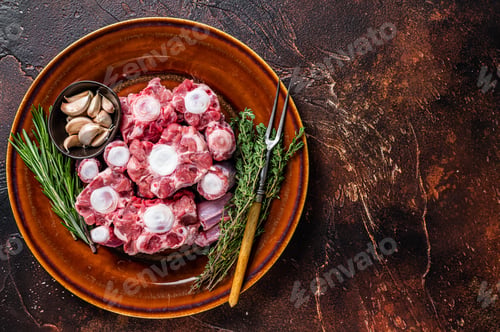 Preview: Fresh uncooked beef Oxtail cut Meat on rustic plate with herbs.