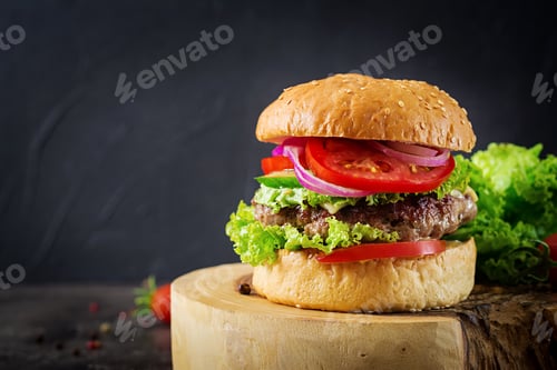 Preview: Hamburger with beef meat burger and fresh vegetables on dark background. Tasty food.