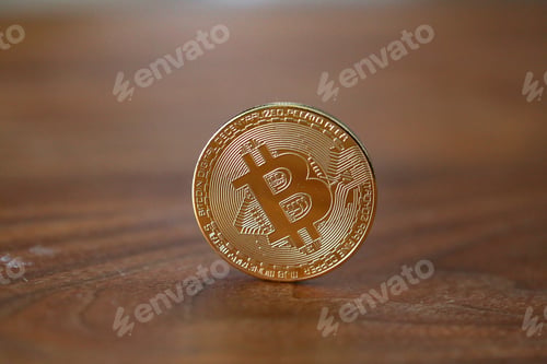 Preview: Selective focus closeup of a golden coin with the B in the middle - the concept of Bitcoin currency