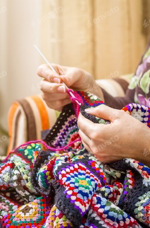 Preview: Woman Crocheting a Colorful Blanket at Home