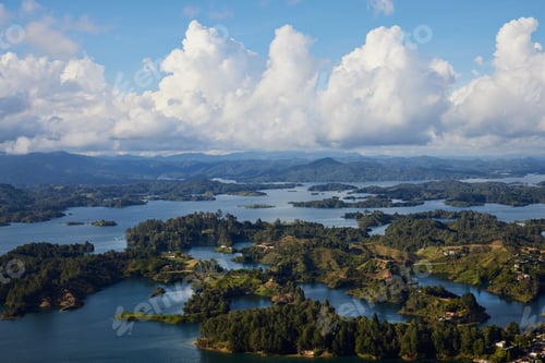 Vorschau: Luftaufnahme der Stadt Guatape in Kolumbien mit Bergen und bewölktem Himmel im Hintergrund