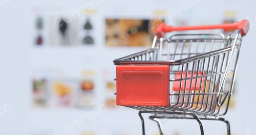 Preview: Shopping online concept, small cart over shopping online website