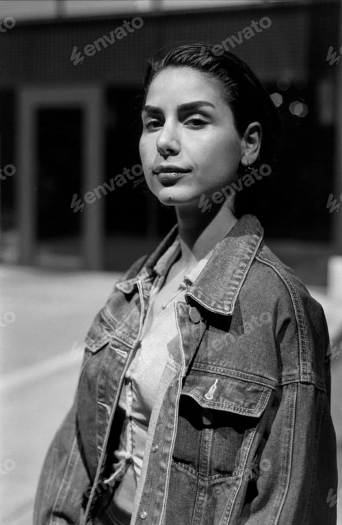 Preview: Young woman wearing denim jacket posing in black and white analog photo