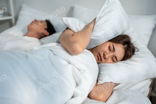 Preview: Asian beautiful woman feel frustrated from husband snoring while sleep.