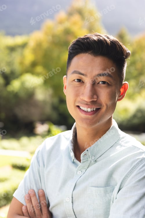 Preview: Portrait of happy asian man smiling in sunny garden