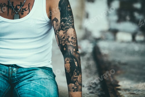 Preview: Man with tattoo on arm posing outdoors