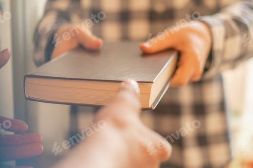 Preview: two people exchange the book, giving the knowledge to younger generations