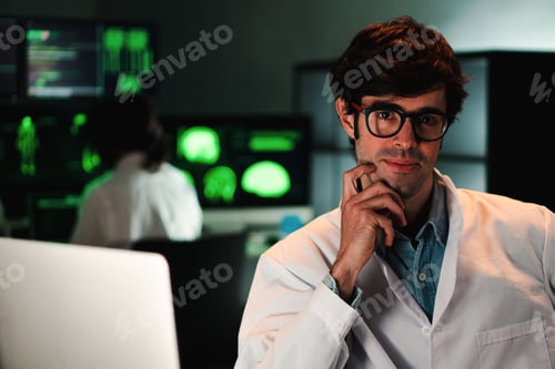 Preview: Close up portrait of attractive medical doctor with glasses and lab coat looking at camera. Front