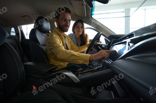Preview: Young couple choosing auto in car showroom