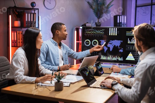 Preview: Multi ethnic team of brokers using gadgets for work at office