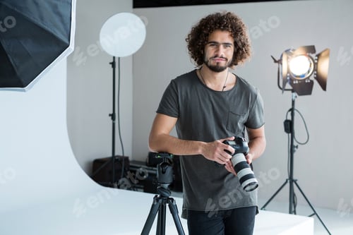 Preview: Happy male photographer standing in studio