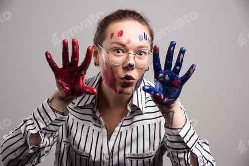 Preview: Woman with paints on her face and glasses on gray background