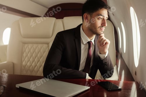 Man Looks Out Window While Flying Private Jet