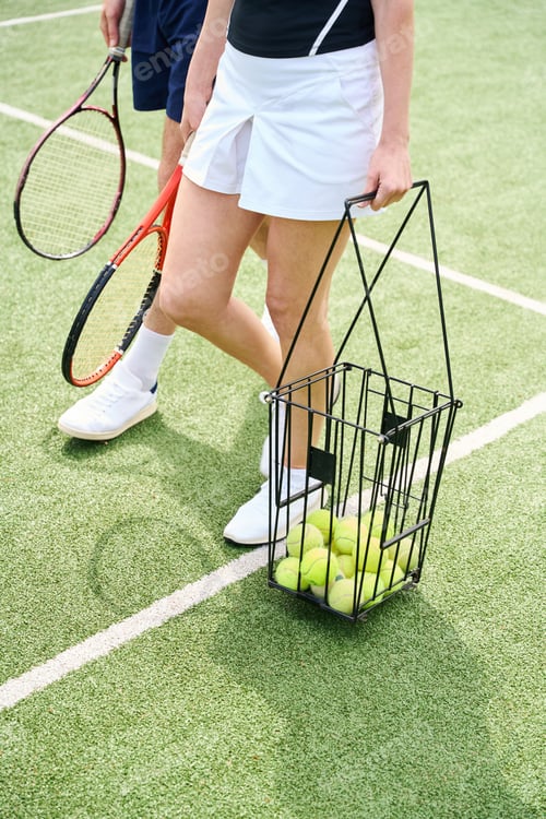 Preview: Spouses walk with rackets and basket of balls on tennis court