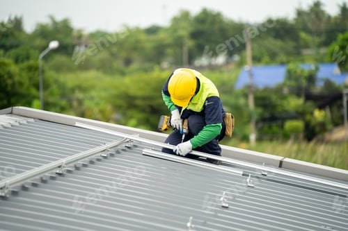 Preview: Men technicians mounting photovoltaic solar moduls on rooftop of warehouse.