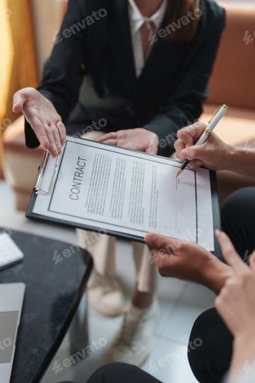 Preview: Business people signing contract during corporate meeting