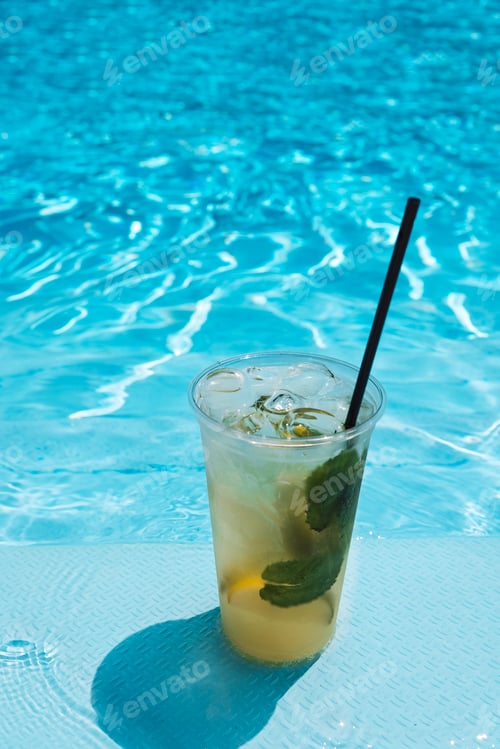 Preview: Delicious ice drink with lime, lemon and mint on the side of the pool.
