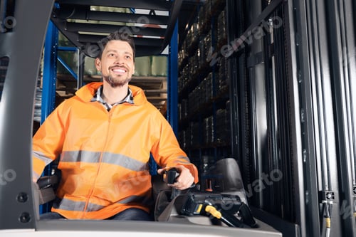 Preview: Happy worker sitting in forklift truck at warehouse