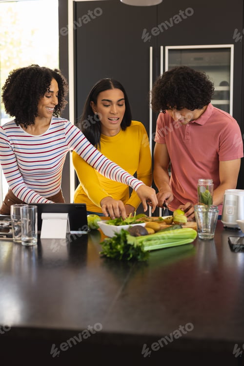 Preview: Happy diverse friends cooking and smiling together in kitchen