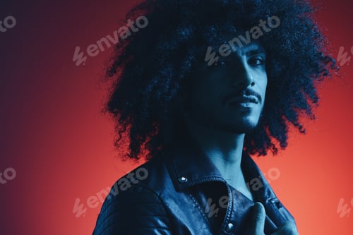 Preview: Portrait of fashion man with curly hair on red background multinational, colored light, black