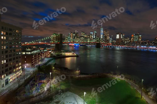 Preview: New York City Manhattan Skyline panorama at dawn with skyscrapers illuminated over East river.