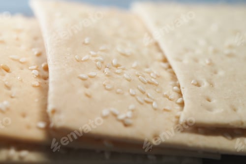 Preview: Sesame crackers displayed on a wooden tray in a warm kitchen