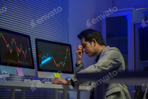 Preview: Stressed stockbroker having headache while looking at failing investment on computer screens
