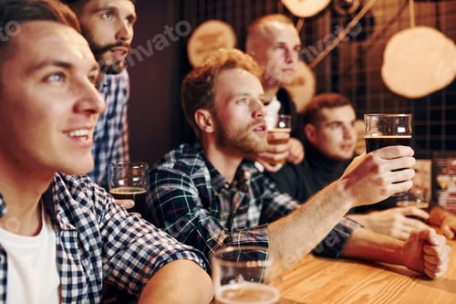 Preview: Fans cheer and shout. Group of people together indoors in the pub have fun at weekend time