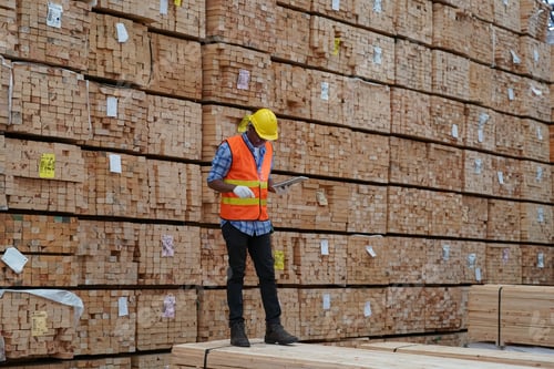 Preview: Warehouse worker working on planks of wood in wooden manufacturing