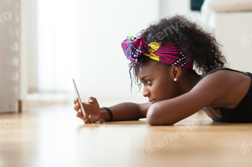 Preview: African American woman sending a text message on a mobile phone