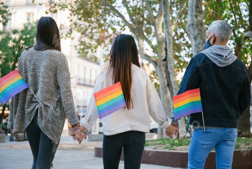 Preview: Unrecognizable people with rainbow flags in city
