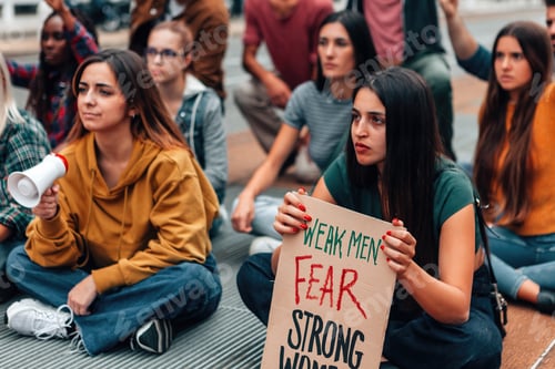 Preview: young crowd sitting on street protesting for gender equality - panel with weak men fear strong women