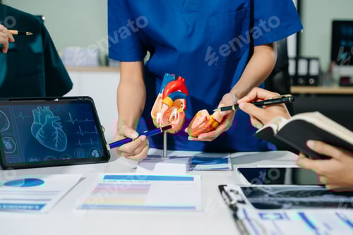 Preview: Group of medical students in uniform studying heart anatomy with tablet, notes, and lab reports