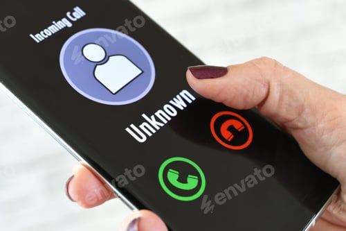Preview: Hand holding cellphone with incoming call from Unknown Caller - fraud scam phishing call spoofing