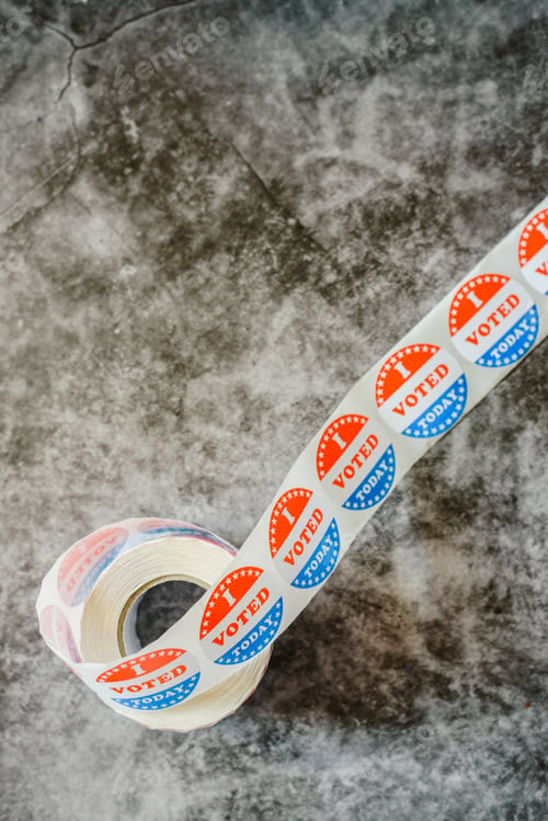 Preview: Roll of "I voted" circular stickers on a gray background for the November elections