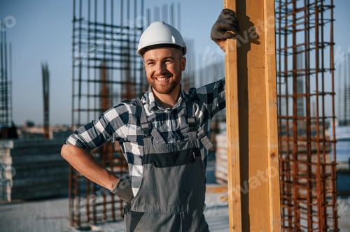 Preview: Standing and smiling. Man is working on the construction site at daytime
