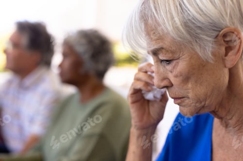 Preview: Close-up of asian senior woman crying while sitting with multiracial friends in nursing home