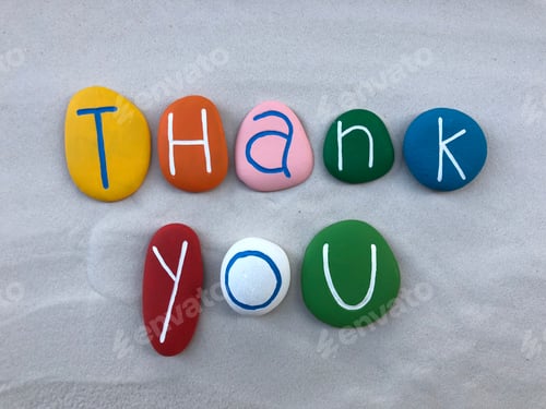 Preview: Thank you text with multi colored stones over white sand