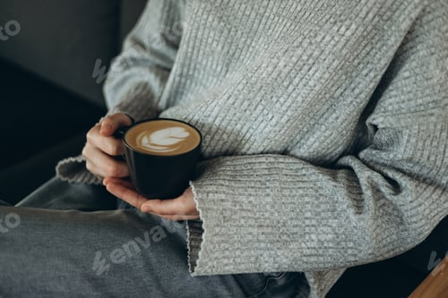Preview: Cozy moment with coffee cup and latte art in warm attire