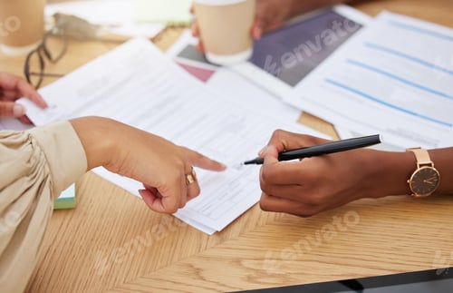 Preview: Closeup of two unknown ethnic business woman sitting and signing office contract. Mixed race profes