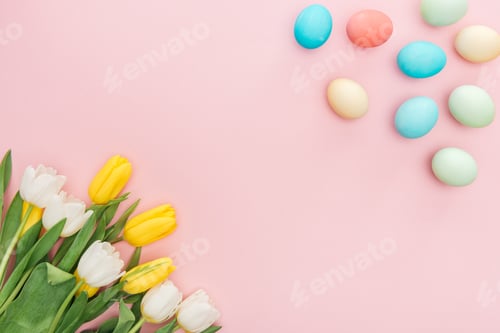 Preview: top view of tulip flowers and traditional easter eggs isolated on pink