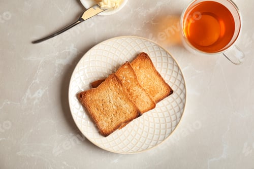 Preview: Plate with toasted bread and cup of tea on light background, top view