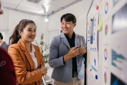 Preview: Smiling asian business colleagues discussing strategy during a meeting in the office, analyzing fina