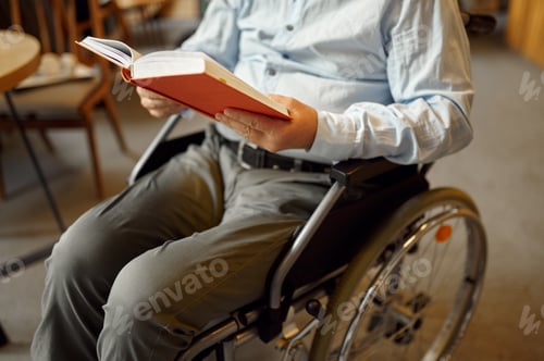 Preview: Adult disabled man in wheelchair reading a book