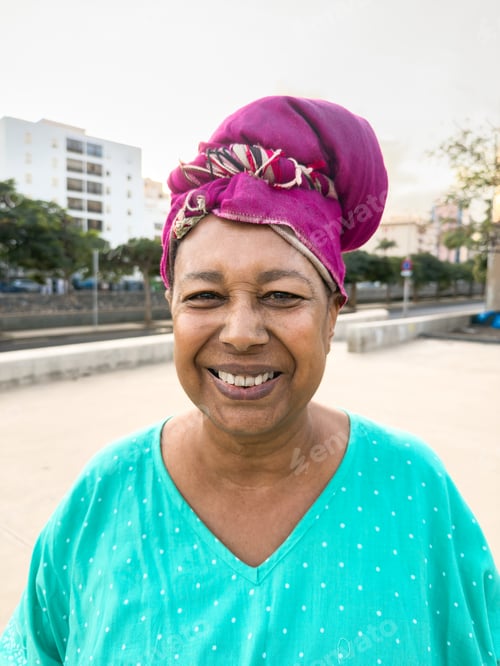 Preview: Happy african senior woman smiling on camera while wearing traditional clothes