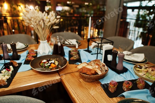 Preview: Beautifully laid tables with food, glasses and appliances in restaurant.
