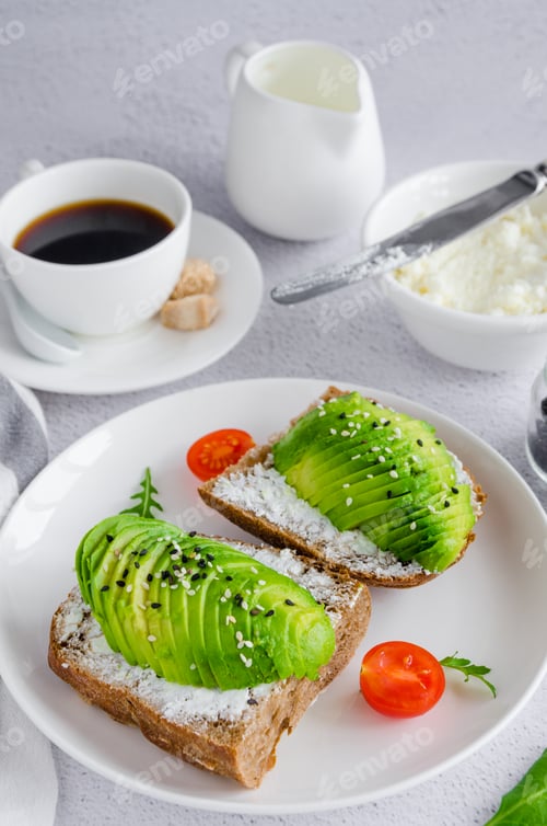 Preview: Avocado sandwich on dark rye toast bread made with fresh sliced avocado, cream cheese and seeds