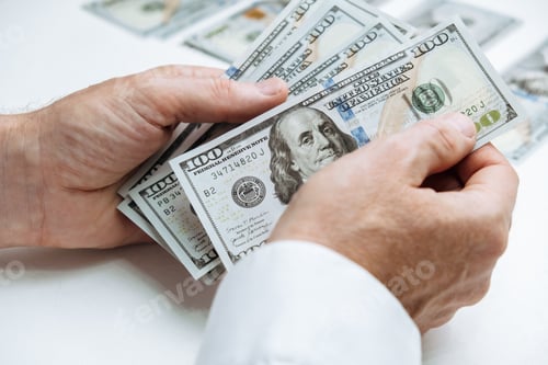 Preview: man counts cash hundred-dollar bills of the USA and puts them in stacks. employee's salary.