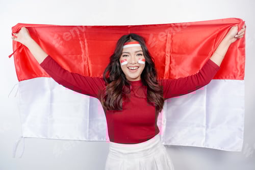 Preview: Happy smiling Indonesian woman holding Indonesia's flag to celebrate Indonesia Independence Day.